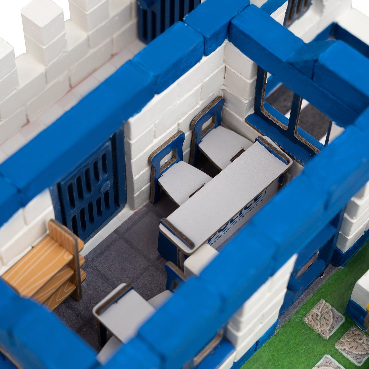 Toy model of a building with blue and white structure, including desks and chairs.