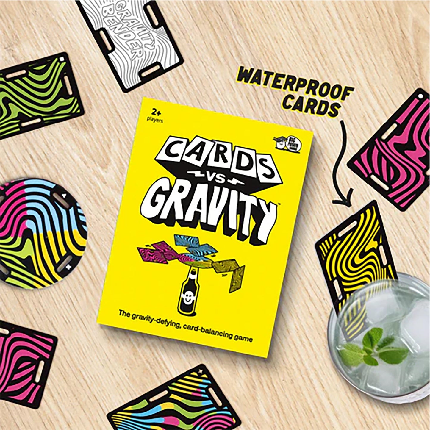 Cards vs. Gravity game packaging on a wooden surface with cards around