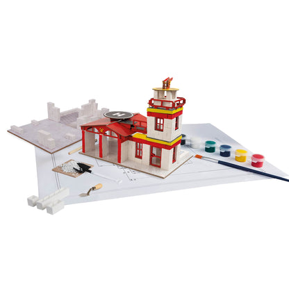 Model of a fire station with tools and paint supplies on a white background