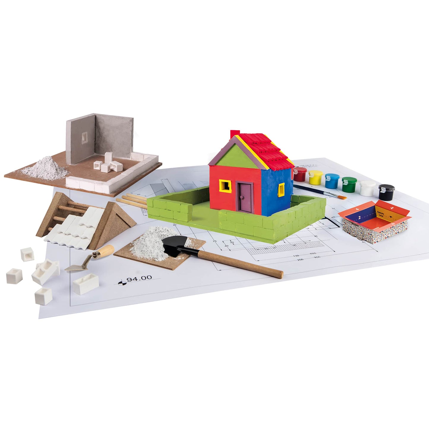 Colorful toy house set on a white surface with tools and materials.