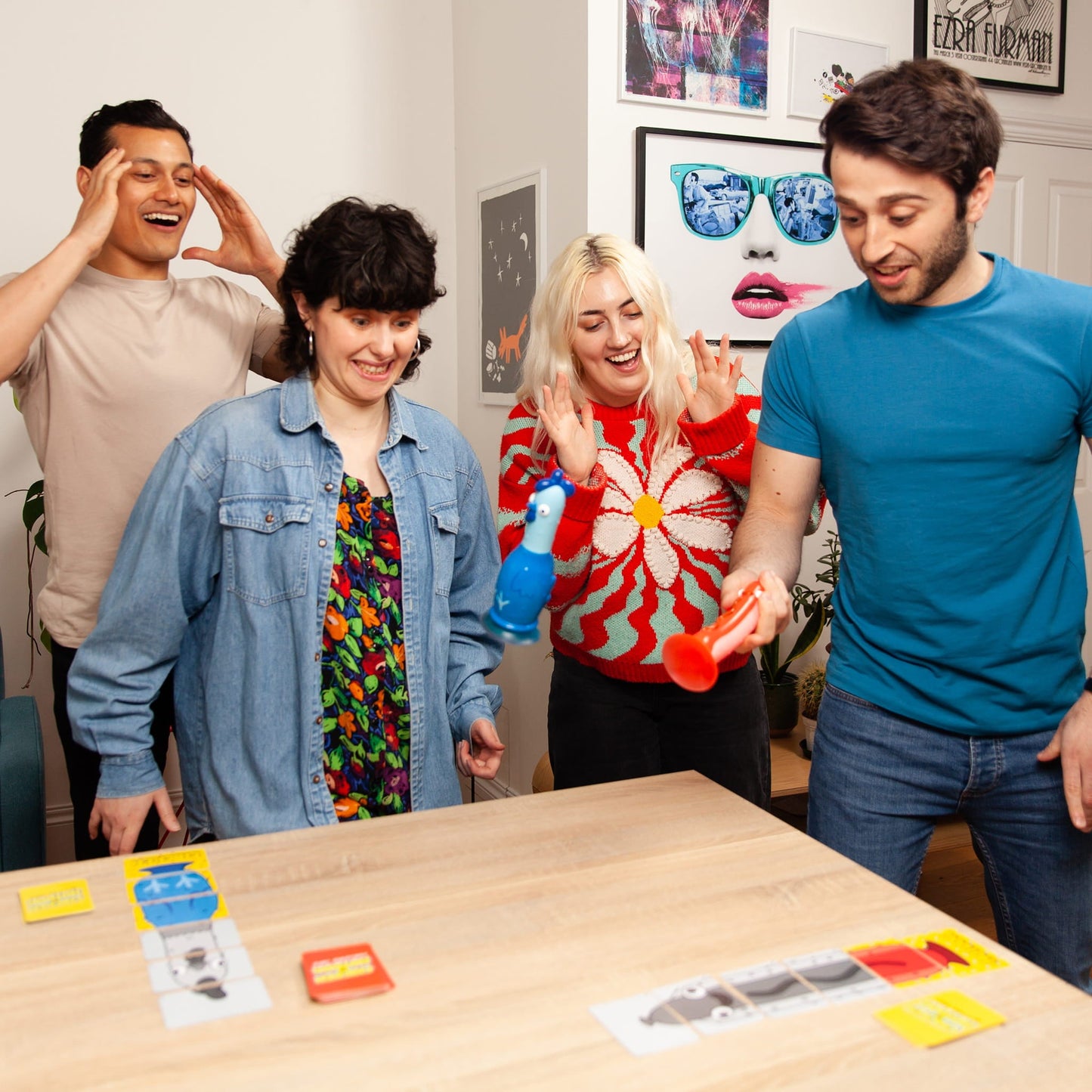 Four friends playing chicken vs hotdog together at a table with colorful cards.