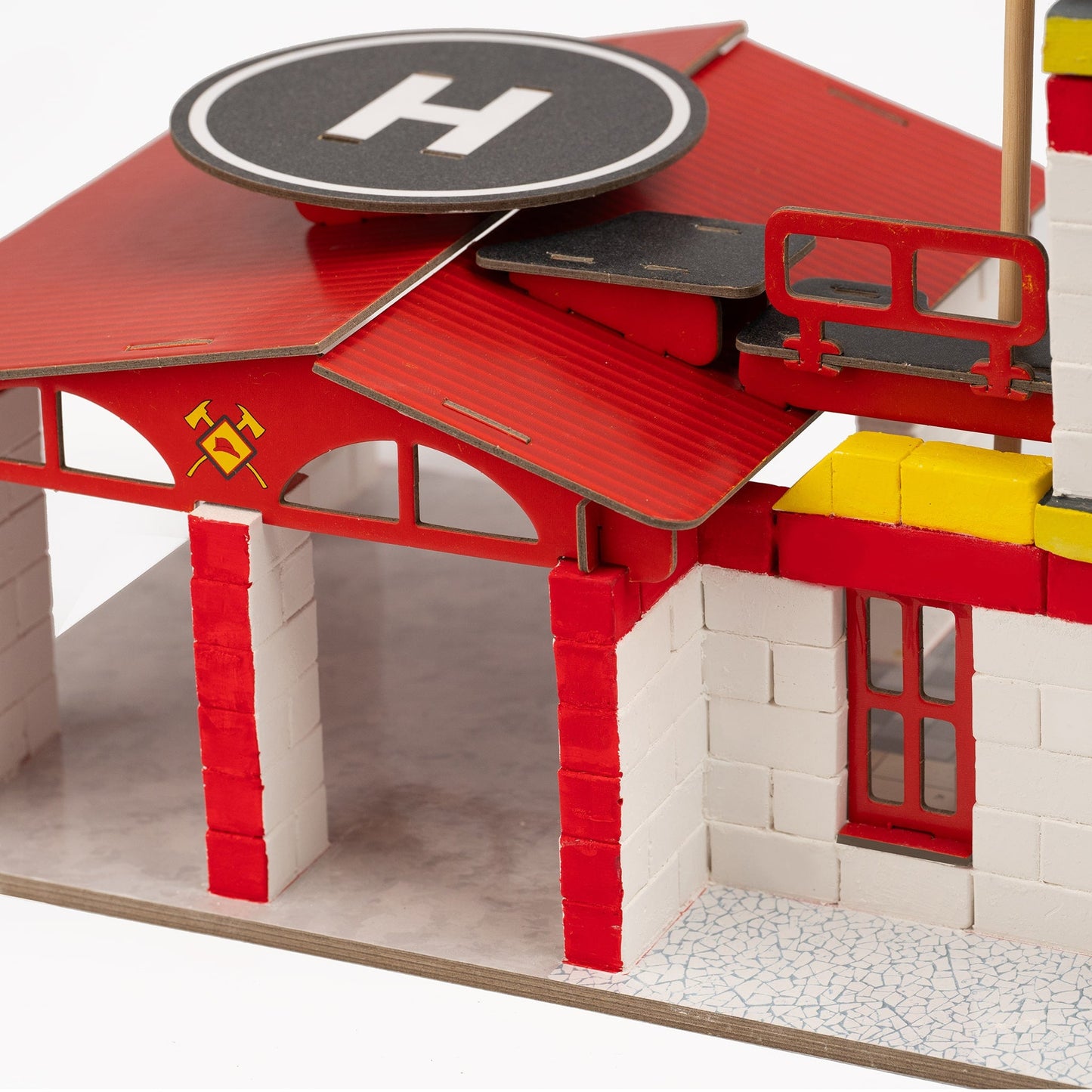Model fire station with red roof and white walls on a white background