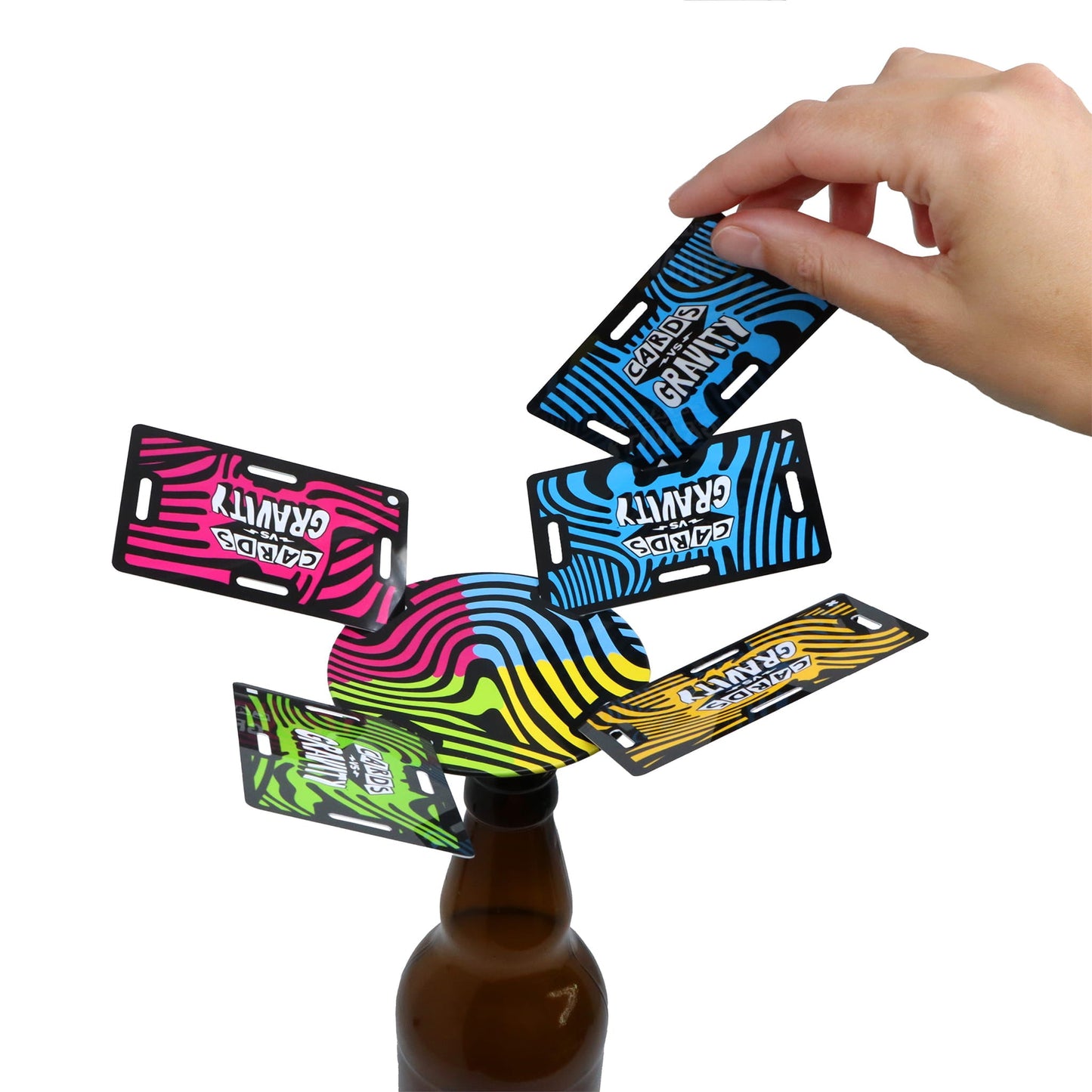 Colorful cards balancing above a bottle on a white background